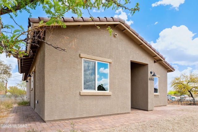 6860 W Walking M, Tucson, AZ 85757 - view of side of property featuring a patio area, stucco siding, and fence