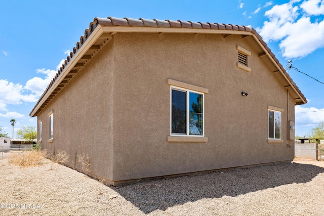 6860 W Walking M, Tucson, AZ 85757 - view of side of property featuring stucco siding and fence