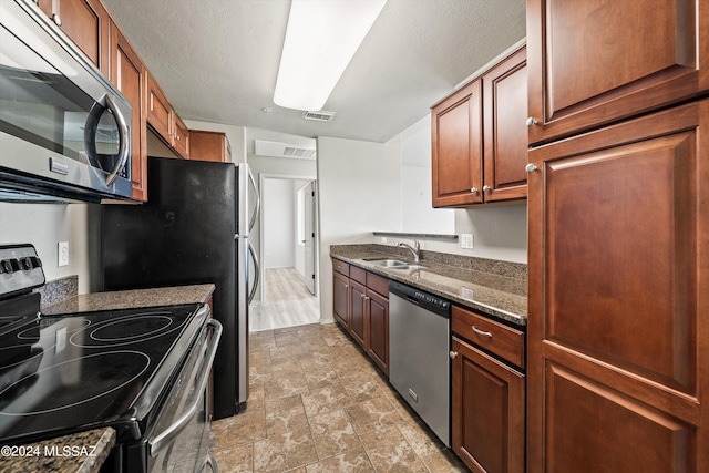 kitchen featuring sink, appliances with stainless steel finishes, and dark stone counters