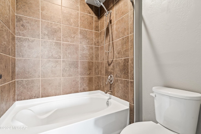 bathroom with tiled shower / bath combo and toilet