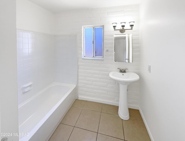 bathroom with a tub to relax in and tile patterned floors