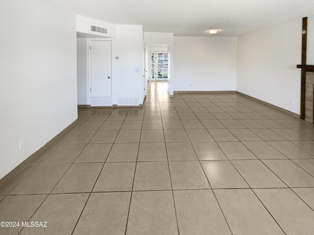 empty room featuring light tile patterned floors and a textured ceiling