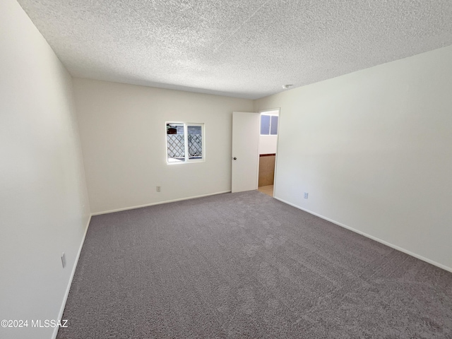 unfurnished room with carpet floors and a textured ceiling