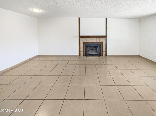 unfurnished living room featuring light tile patterned floors, a textured ceiling, and a tiled fireplace