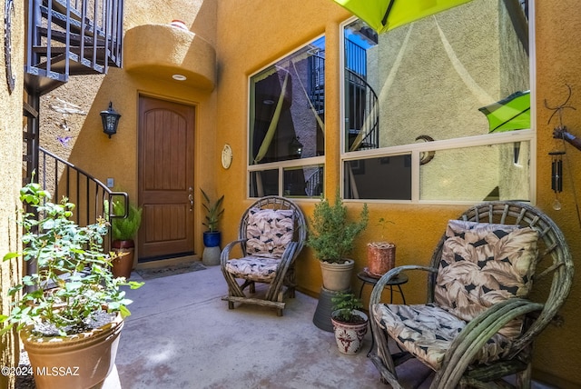 exterior space featuring a pergola, stucco siding, and a gate