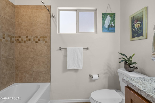 full bathroom with tiled shower / bath, vanity, and toilet