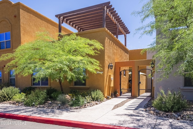 property entrance featuring a gate and stucco siding