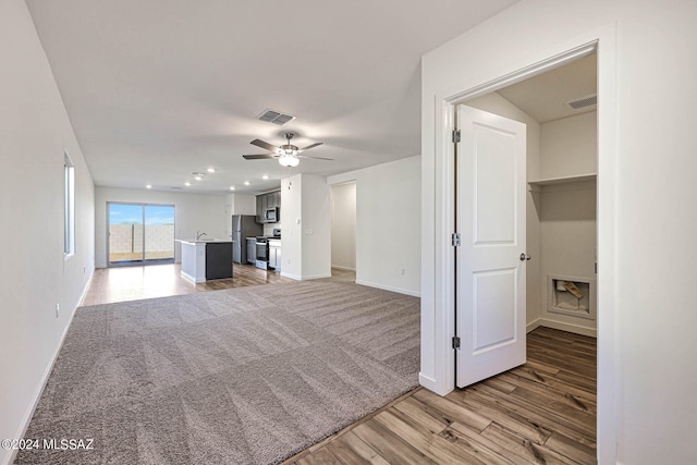 unfurnished living room with ceiling fan and light hardwood / wood-style flooring