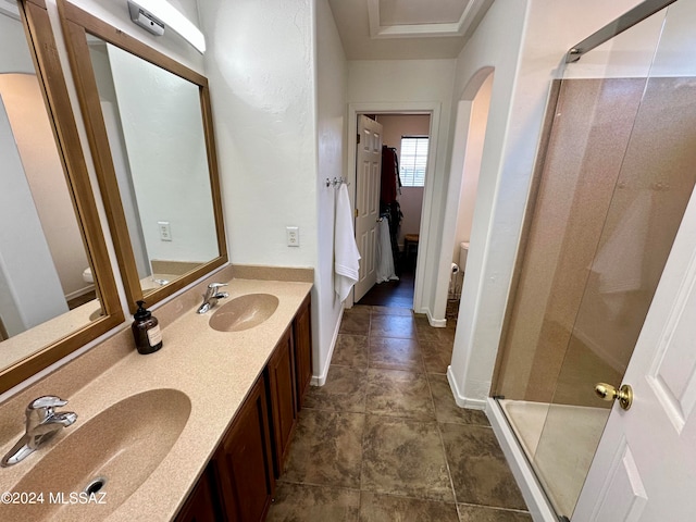 bathroom featuring vanity, toilet, and a shower with door