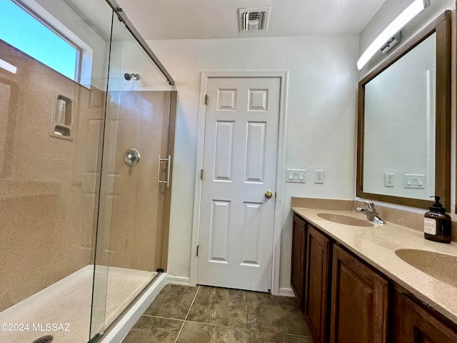 bathroom with tile patterned flooring, walk in shower, and vanity