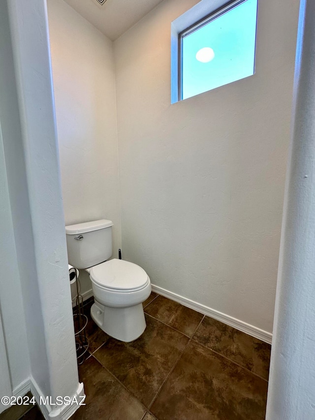 bathroom featuring toilet and tile patterned flooring