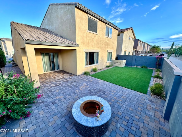 rear view of property featuring a lawn and a patio