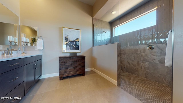 bathroom with tile patterned floors, vanity, and tiled shower