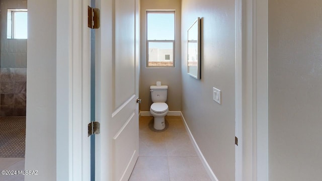 bathroom featuring tile patterned floors, toilet, and a healthy amount of sunlight