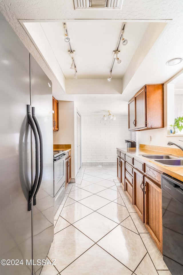 kitchen featuring sink, light tile patterned floors, white electric stove, dishwasher, and stainless steel refrigerator