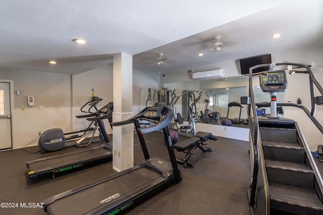 gym with an AC wall unit and ceiling fan