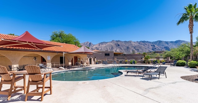 view of swimming pool featuring a mountain view and a patio area