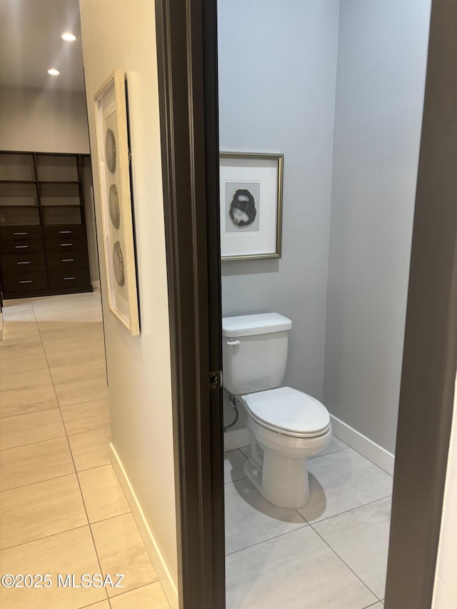 bathroom featuring tile patterned floors, baseboards, and toilet