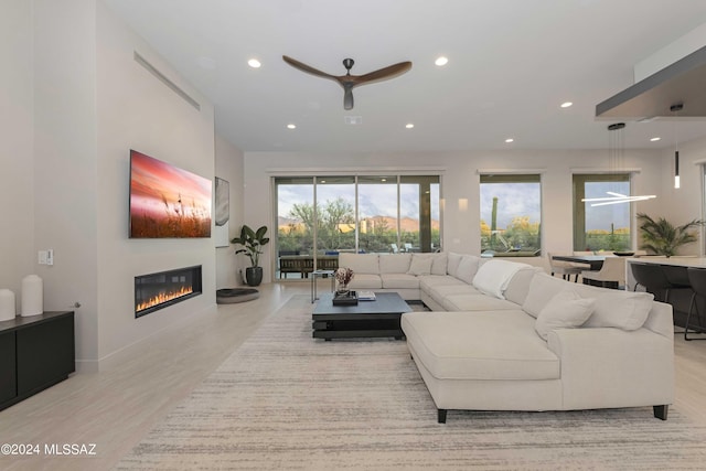 living room featuring light hardwood / wood-style flooring and ceiling fan