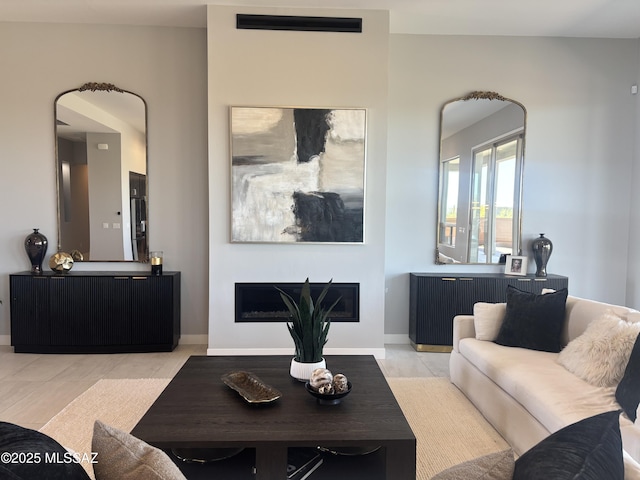 living area featuring a fireplace and baseboards