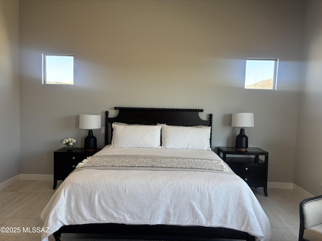 bedroom featuring light tile patterned floors and baseboards