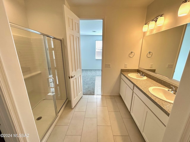 bathroom with tile patterned floors, vanity, and an enclosed shower