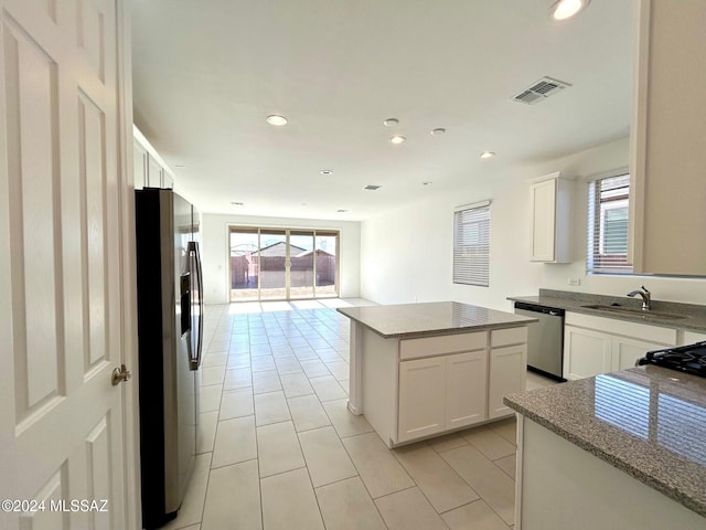 kitchen featuring a center island, white cabinets, stainless steel appliances, and sink