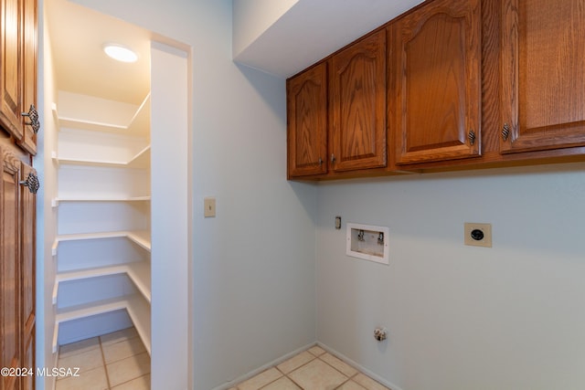 washroom featuring gas dryer hookup, cabinets, hookup for a washing machine, light tile patterned floors, and hookup for an electric dryer