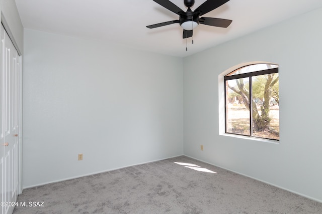 carpeted empty room featuring ceiling fan