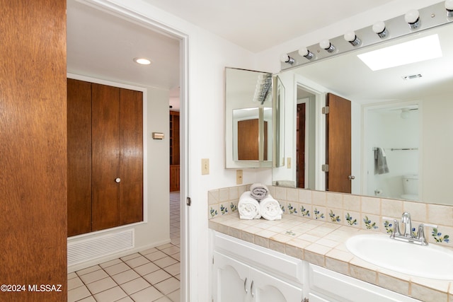 bathroom with tile patterned floors, vanity, toilet, and tasteful backsplash