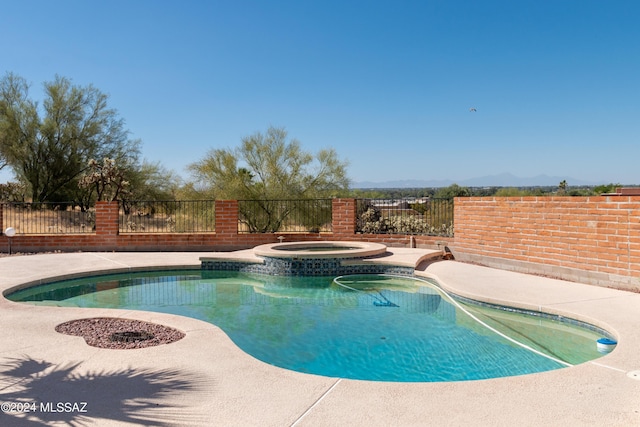 view of swimming pool with an in ground hot tub and a mountain view