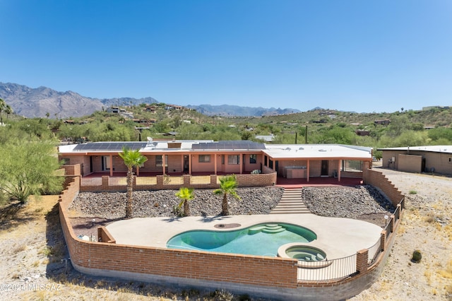 rear view of house featuring a patio area, a mountain view, and solar panels