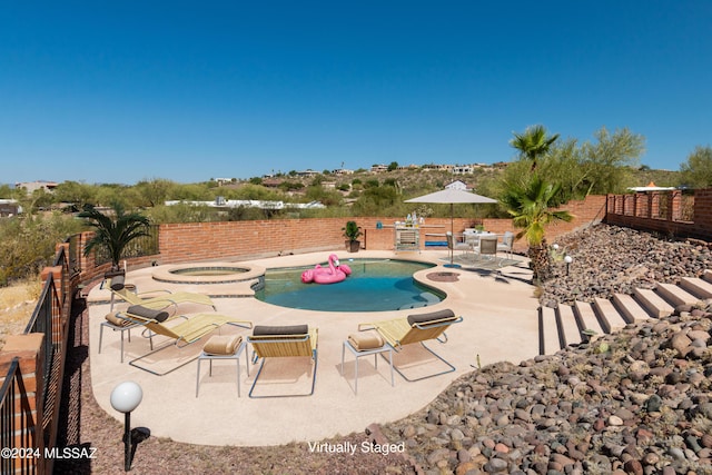 view of swimming pool with an in ground hot tub and a patio