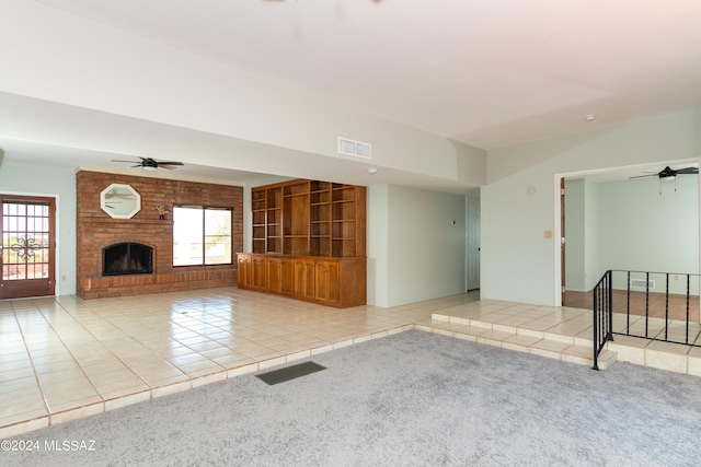 unfurnished living room featuring light tile patterned flooring, a healthy amount of sunlight, and a brick fireplace