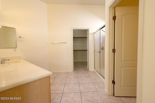 bathroom with a shower with door, tile patterned flooring, and vanity