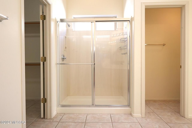 bathroom featuring a shower with shower door and tile patterned flooring