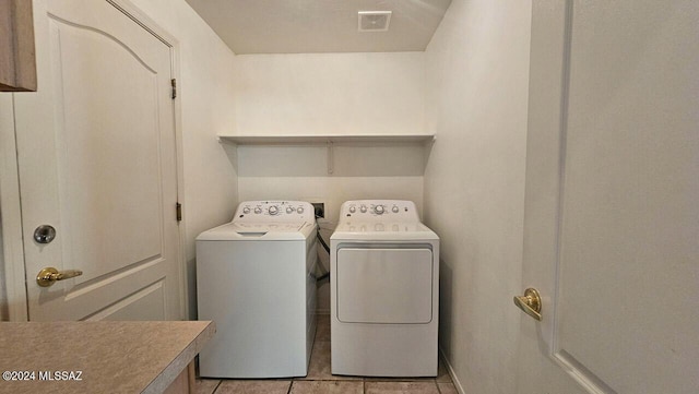 laundry room featuring washing machine and dryer and light tile patterned floors