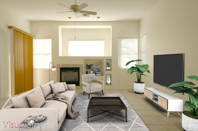 tiled living room featuring a tiled fireplace, plenty of natural light, and ceiling fan