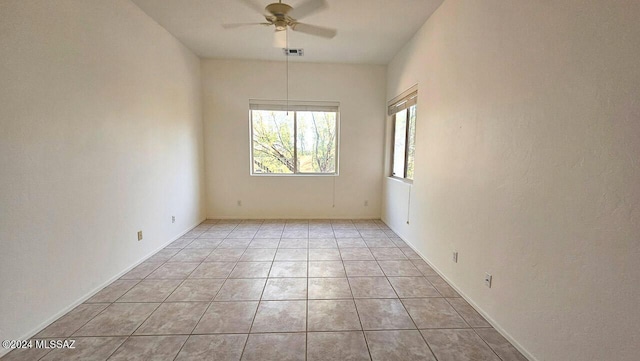 tiled spare room featuring ceiling fan