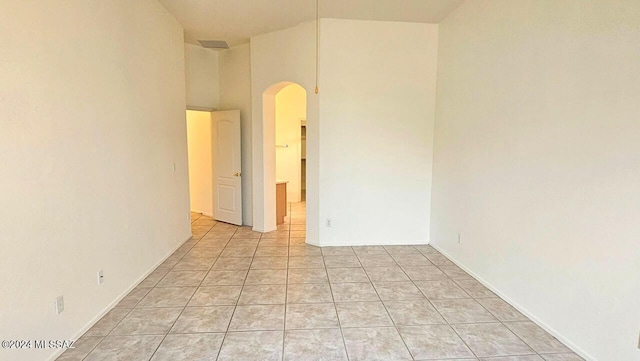 tiled empty room with a high ceiling