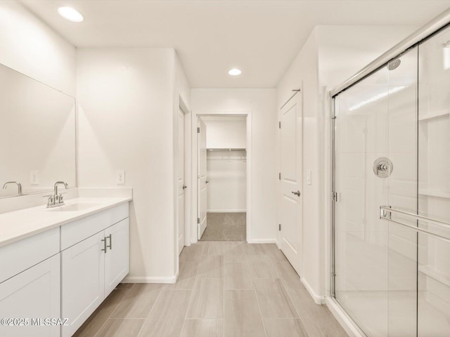 bathroom featuring walk in shower and vanity