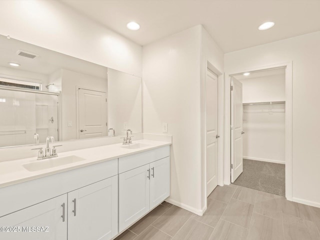 bathroom featuring vanity and a shower with door