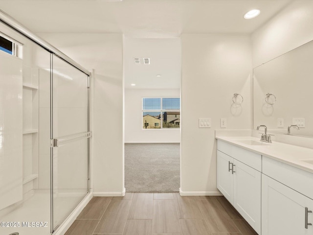 bathroom with vanity and a shower with shower door