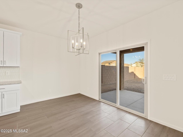 unfurnished dining area with a notable chandelier and light hardwood / wood-style flooring