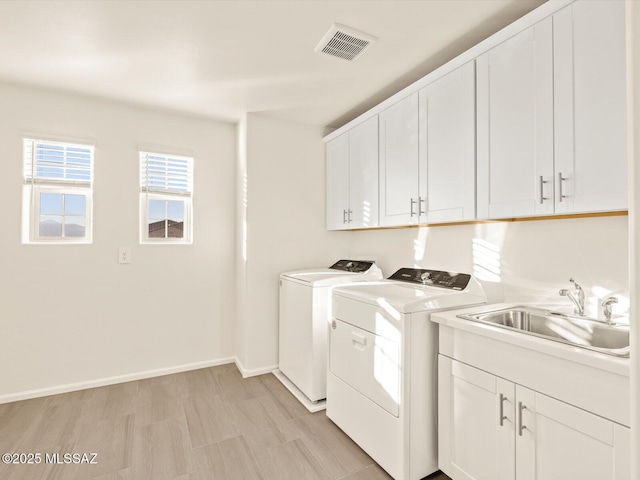 laundry area with cabinets, sink, and washing machine and dryer