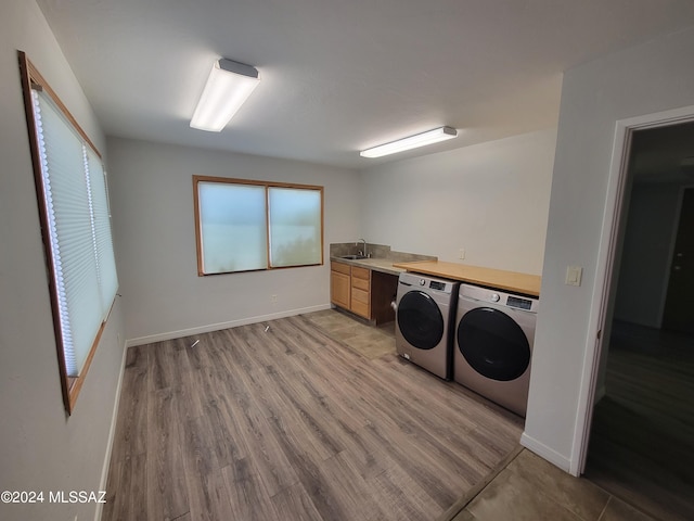 washroom featuring separate washer and dryer, sink, and light wood-type flooring