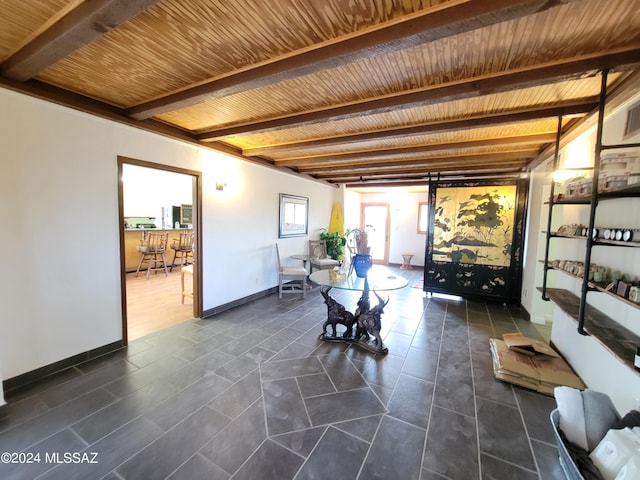 interior space featuring wood ceiling, beam ceiling, and dark tile patterned flooring