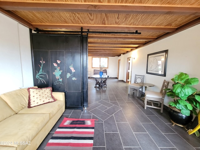 living room with dark tile patterned flooring, wood ceiling, a barn door, and beamed ceiling