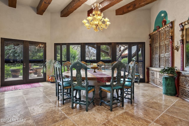 dining space with a chandelier, beam ceiling, a towering ceiling, and french doors