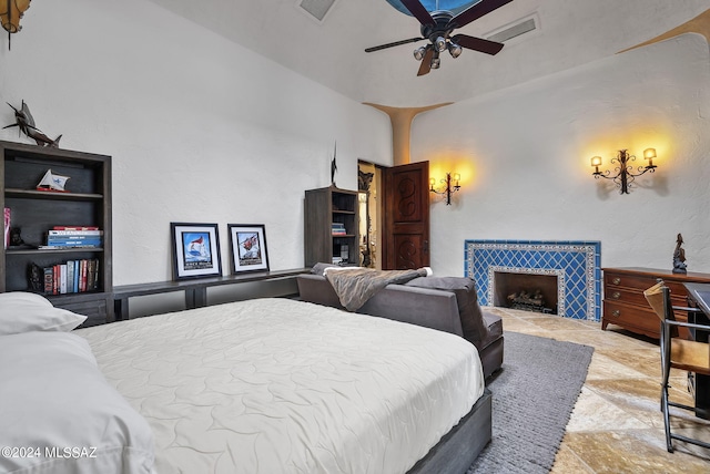 bedroom with ceiling fan and a fireplace